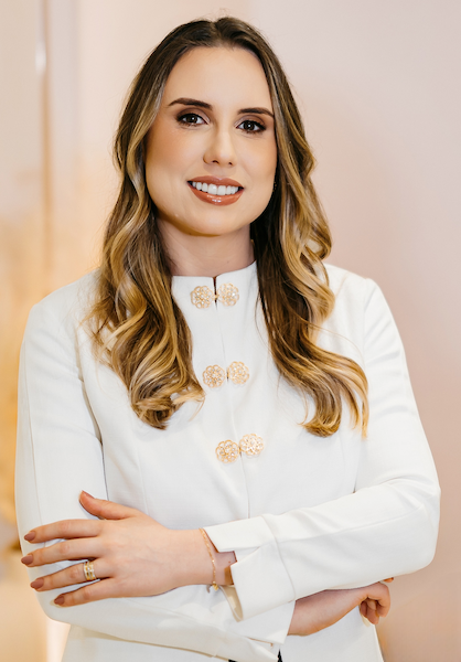 Mulher vestida com jaleco branco e sorrindo